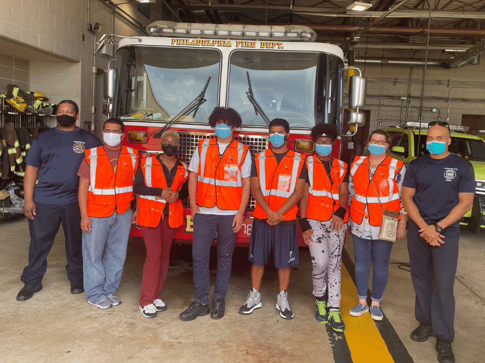 Students standing in front of a fire rescue vehicle with 2 fire rescue employees for Aviation Career Day in Philadelphia. Event by VelocityR Aviation.